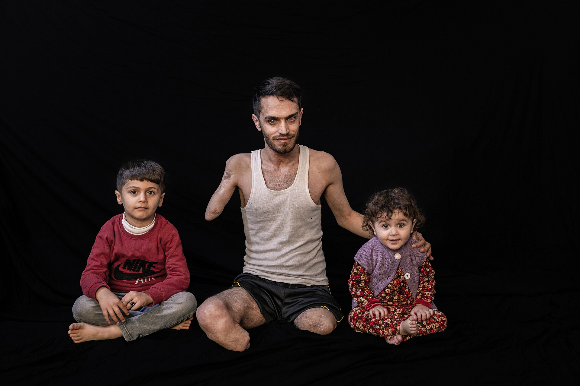 Salman Farman Saleh with his two kids, He was born in 1992 joined the Peshmerga in 2009. He was wounded in fighting ISIS in Dec 2014 in Makhmour near Mosul. As a member of a team that clears IEDs, he was cleaning a field of mines when one exploded near him. The blast took both his legs, one hand, one eye, and an ear. He has a 100% disability. He has two kids.